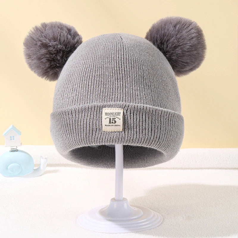 Bonnet bébé tricoté chaud avec pompon